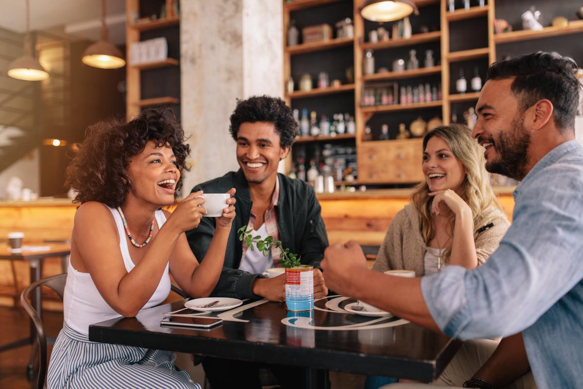 Friends enjoying drinks and conversation at a bar or restaurant table