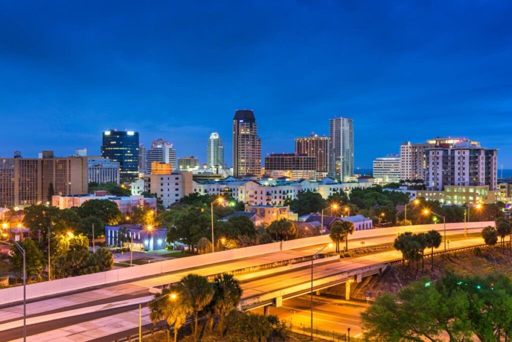 Night city skyline with highway lights and long-exposure traffic trails